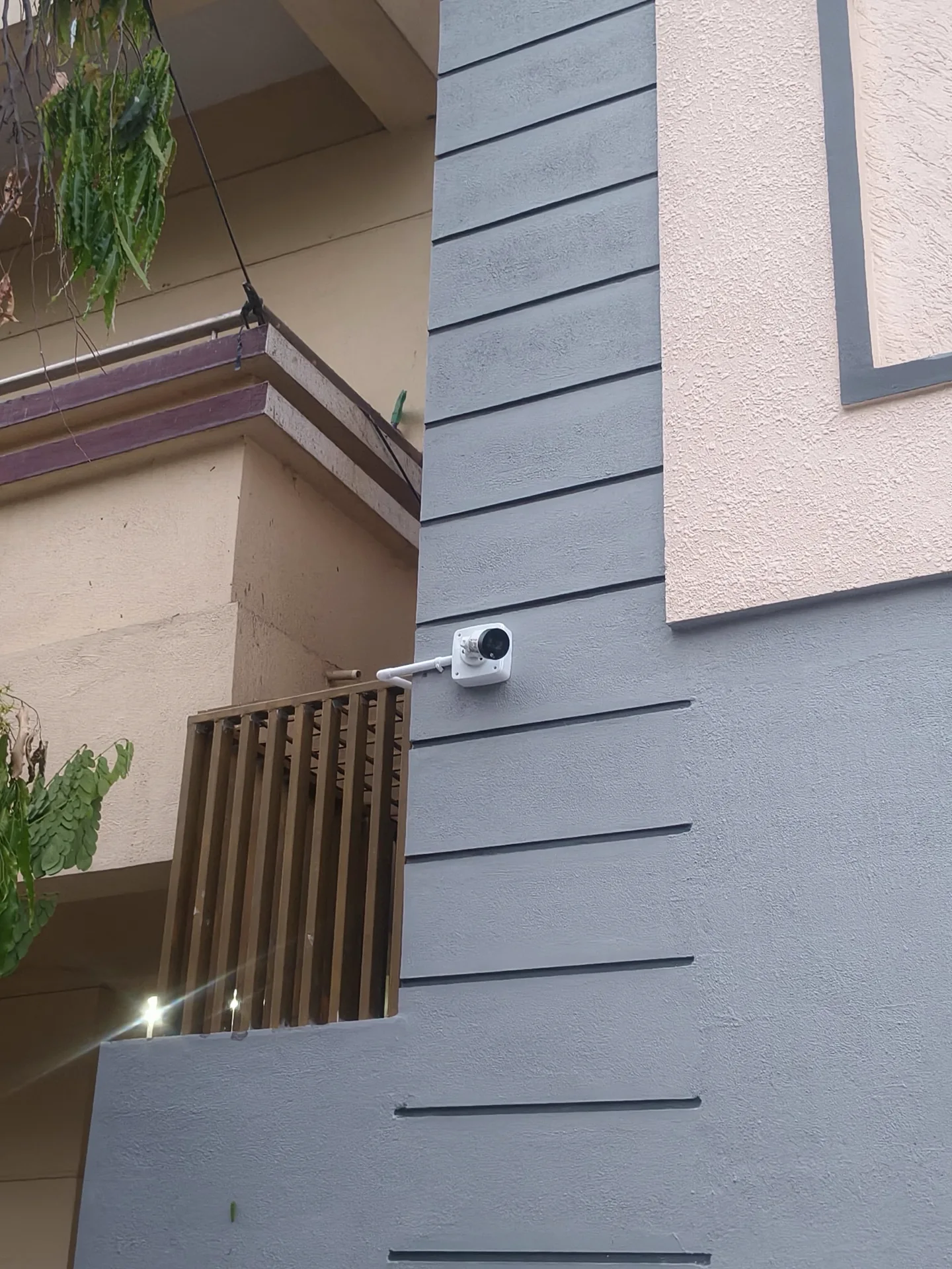 White CCTV camera mounted on the wall beside an entrance
