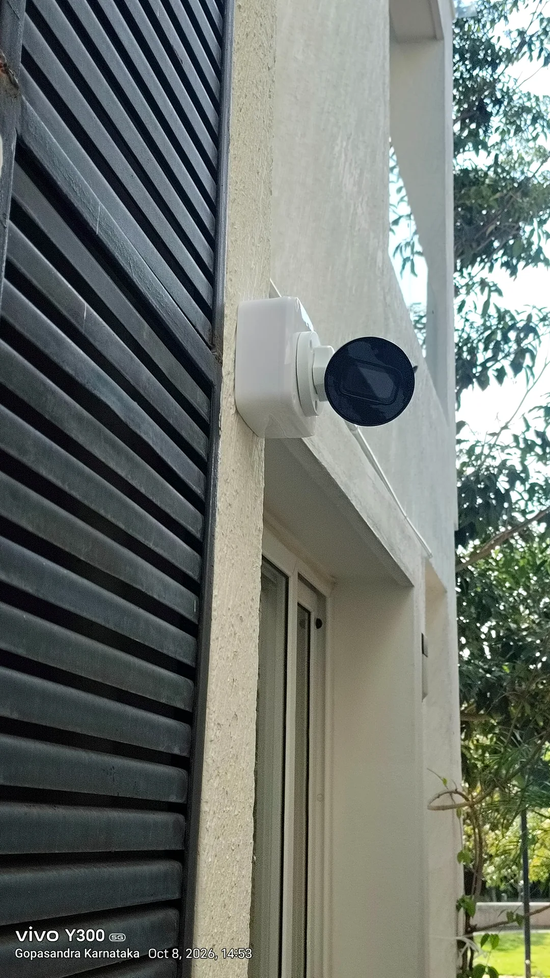 White bullet CCTV camera mounted on an exterior wall