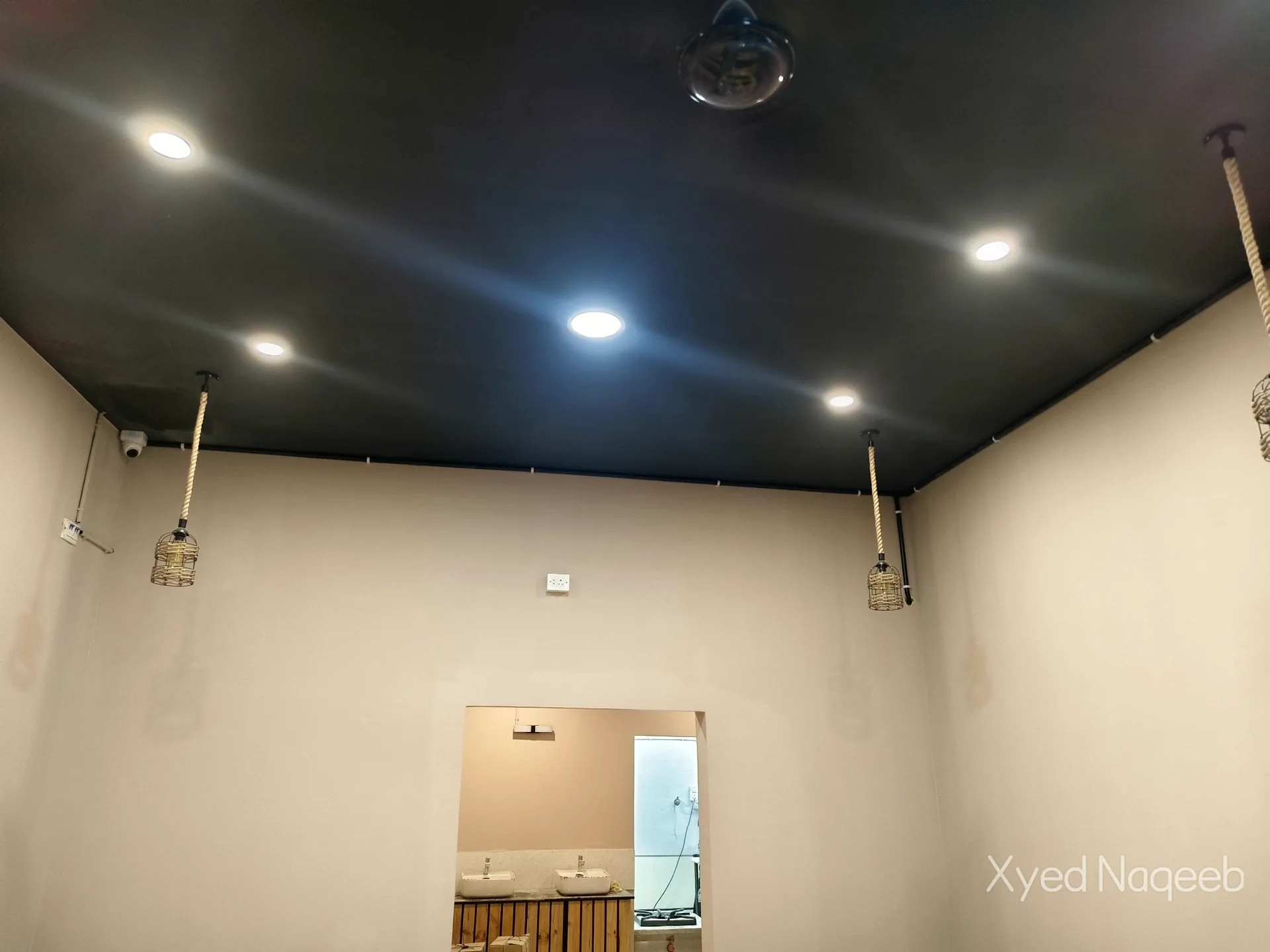 Dome camera on a dark ceiling with recessed lights